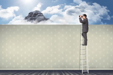 Composite image of businessman standing on ladder using