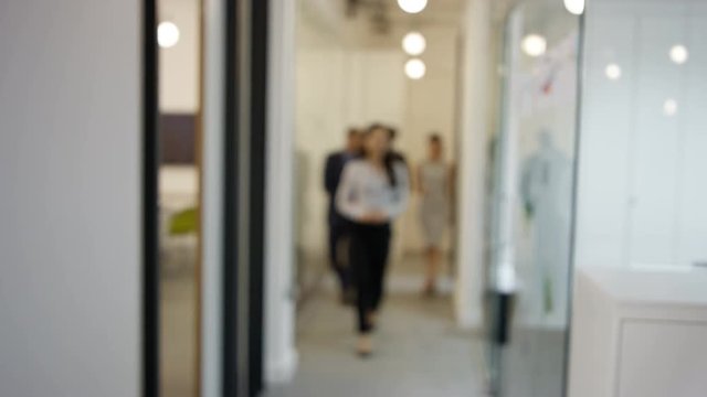  Portrait confident businesswoman in office with colleagues in background