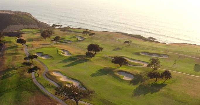 Aerial View Of Golf Course Next To Ocean at Sunset