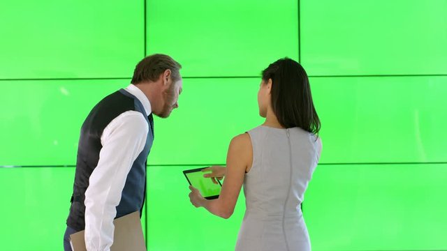  Business man & woman looking at tablet with green screen, on green background