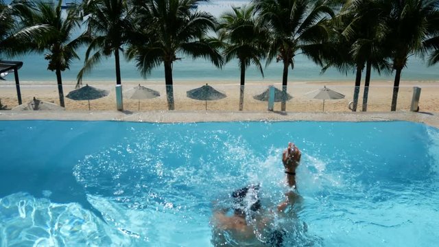 man drowning in water at swimming pool. man drowning in the pool try to survive by put hand up asking for help 
