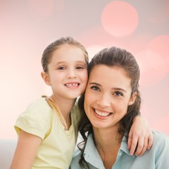 Composite image of cute mother and daughter smiling at camera