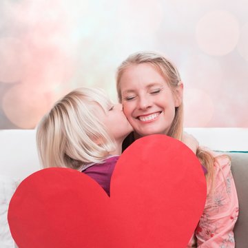 Composite image of happy mother and daughter on the couch with