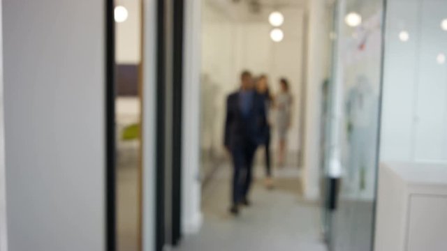  Portrait confident businessman in modern office with colleagues in background