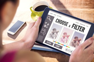 Composite image of woman using tablet pc