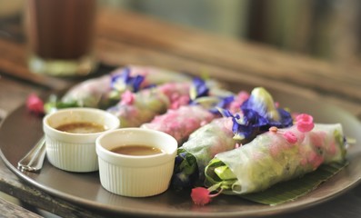 Salad flower roll with sauce.Lettuce, Butterfly pea and Mexican Creeper, Fresh vegetable noodle spring roll.