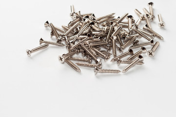 Heap of metal wood screw on white background