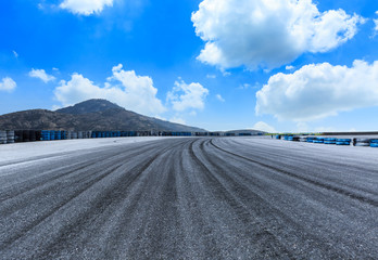 Asphalt road circuit and sky clouds with car tire brake