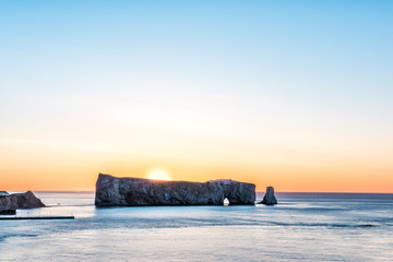 Famous Rocher Perce rock in Gaspe Peninsula, Quebec, Gaspesie region closeup at sunrise with sun hiding behind
