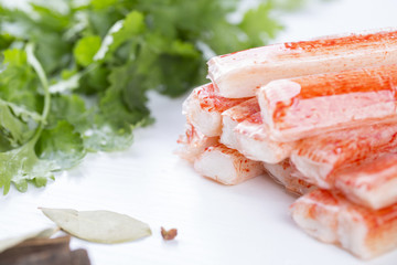 Closeup of crab stick with green lettuce and coriander, pepper and other spices.