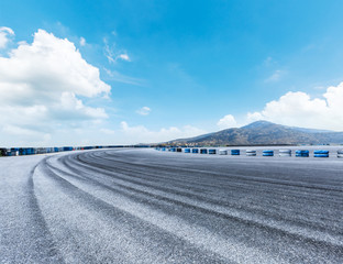 Asphalt road circuit and hill under the blue sky