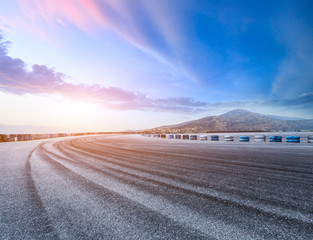 Asphalt road and mountain scenery at sunset