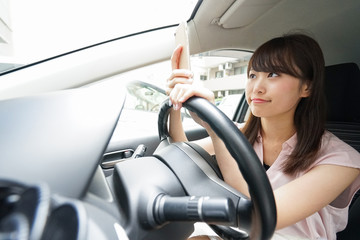 Driving woman using smartphone