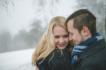 Glückliches Paar in Winterlandschaft mit Wintermantel