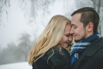 Glückliches Paar in Winterlandschaft mit Wintermantel