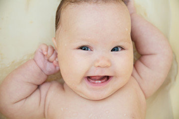 Happy smiling baby girl portrait in bath feeling good. Healthy lifestyle.