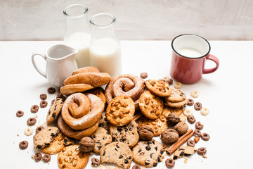Assortment of products eating with milk. Pastry organic breakfast, close up. Wholegrain scones and baked rolls with bottles and cup of lacto drink