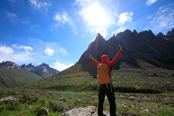 Obraz premium woman hiker with backpack hiking on high altitude mountain
