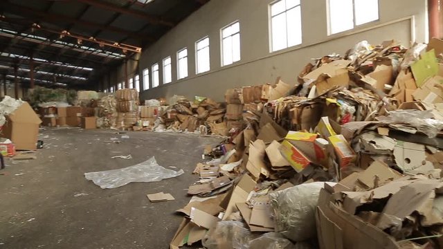 Warehouses with recyclable materials at the garbage processing factory. Huge pile of different paper pieces, closeup view in motion. Large warehouse of waste paper in a factory.