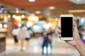 blurred photo and smartphone on shopping mall and people with bokeh.