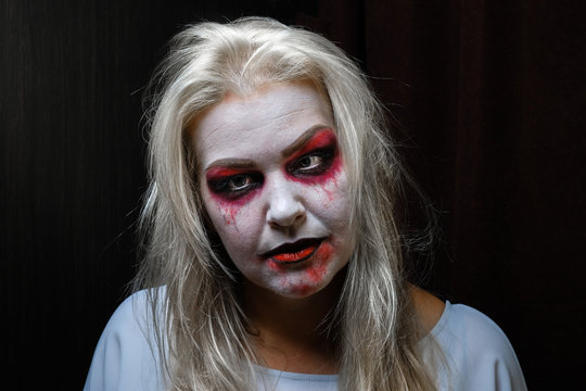 zombie girl with black eyes and a bloody mouth on Halloween