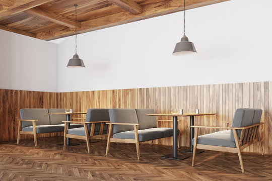 White and wooden cafe interior, sofas side