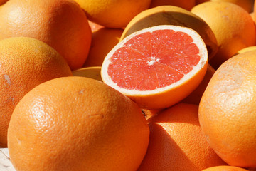 Ripe half of the grapefruit is on the counter at the fruit market in Spain