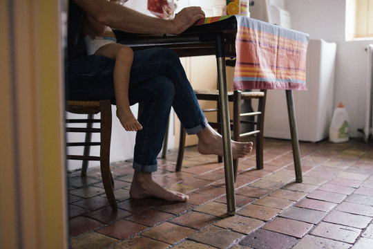 Papa avec son enfant assis &agrave; table dans la cuisine