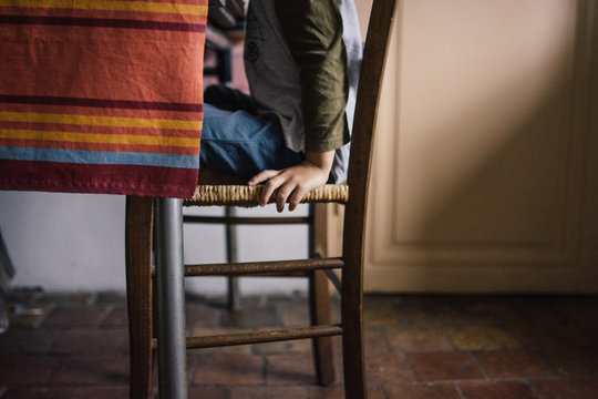 Main de petit gar&ccedil;on assis sur une chaise &agrave; table