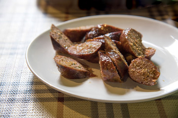 Sai Aua or Northern Thai traditional sausage grill sliced on white plate,Thai spicy sausage, selective focus

