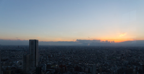 Fototapeta na wymiar Sunset sky view from Tokyo Metropolitan Government Building observation, through glass