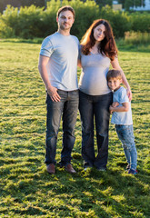 Happy pregnant family of three expecting new baby