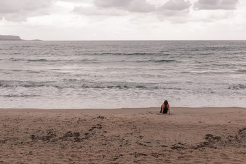 Woman staring at the sea with her back facing the camera