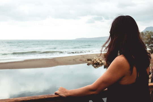 Woman Staring At The Sea With Her Back Facing The Camera