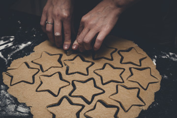Gingerbread Man Cookie Dough Cutout by young girl at the Christmas Time