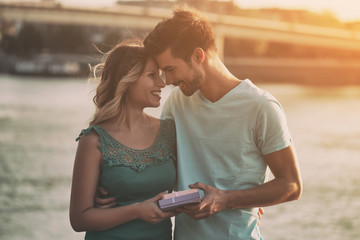 Young man is giving present to his beautiful girlfriend.