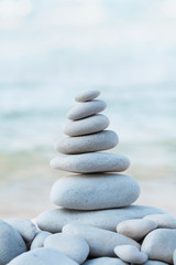Fototapeta na wymiar Spa, balance, meditation and zen concept. Stack of white pebbles stone against sea.