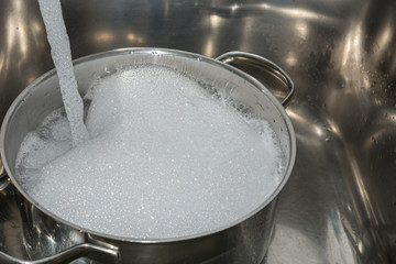 Fototapeta na wymiar Pfanne nach dem Kochen mit Wasser abwaschen