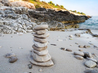 Fototapeta na wymiar Pebbles tower on a sandy beach Mediterranean island in Croatia