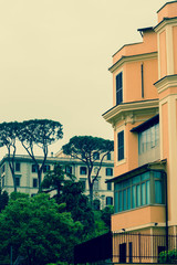  a residential area of ​​Rome with colorful green houses and parked cars in a cool, plentiful day