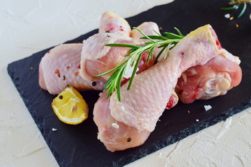 raw chicken legs on a black slate