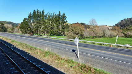 Railway tracks alongside lush green meadows in New Zealand