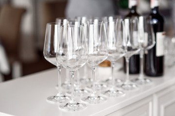 Crystal clear empty wine glasses on the table. Alcohol background. A lot of wine glasses at the bar.