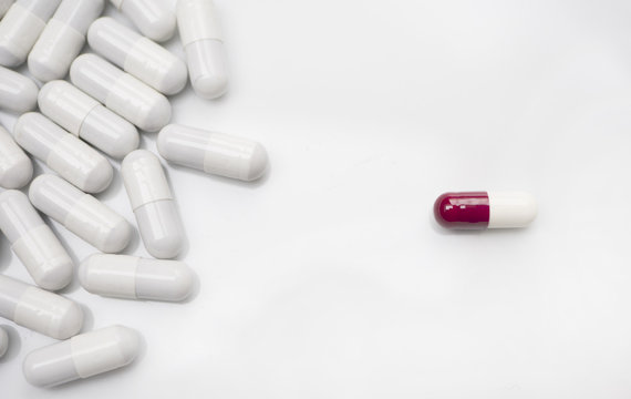 Alone Red Medicine Pill And Many White Pills, White Background