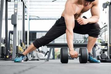 Fototapeta na wymiar man lift dumbbell in gym. bodybuilder male working out in fitness center. sport guy doing exercises in health club.