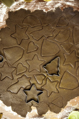 Dough for ginger biscuits rolled up on a table and cut using molds