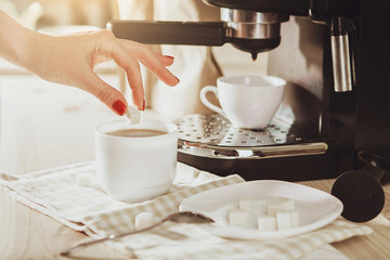 Woman making fresh espresso in coffee maker. coffee machine makes coffee.