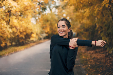 Healthy young woman warming up outdoors.