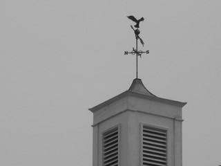 black and white bell tower with weathervane and eagle