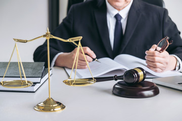 Close up of gavel, Male lawyer or judge working with scales of justice, Law books, report the case on table in modern office, Law and justice concept